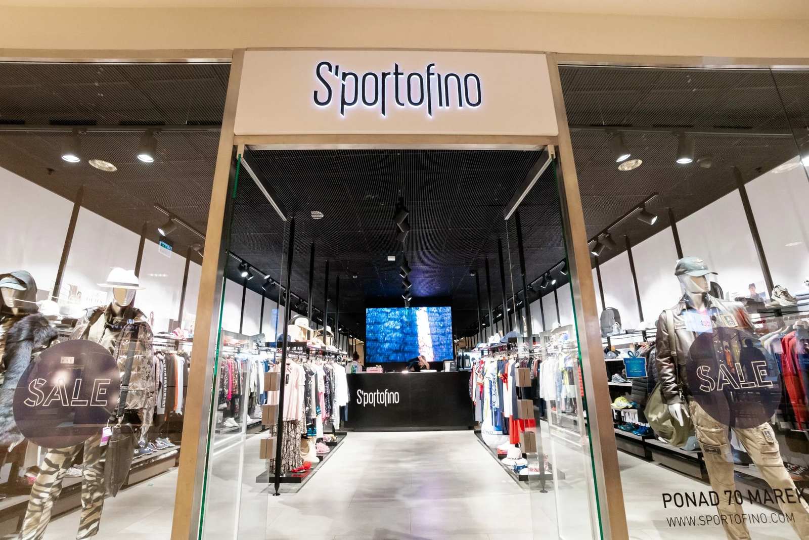 Μαύρη ψευδοροφή μεταλλικού πλέγματος με φωτισμό ράγας σε κατάστημα