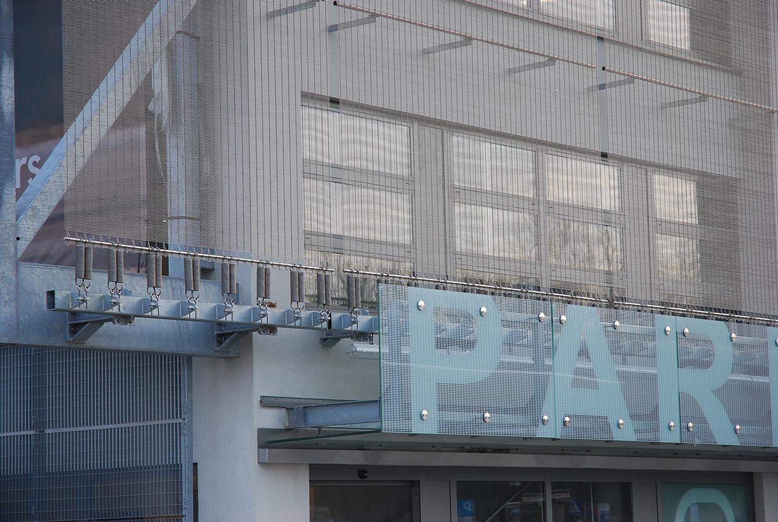 Λεπτομέρεια ανοξείδωτου πλεκτού πλέγματος σε πρόσοψη